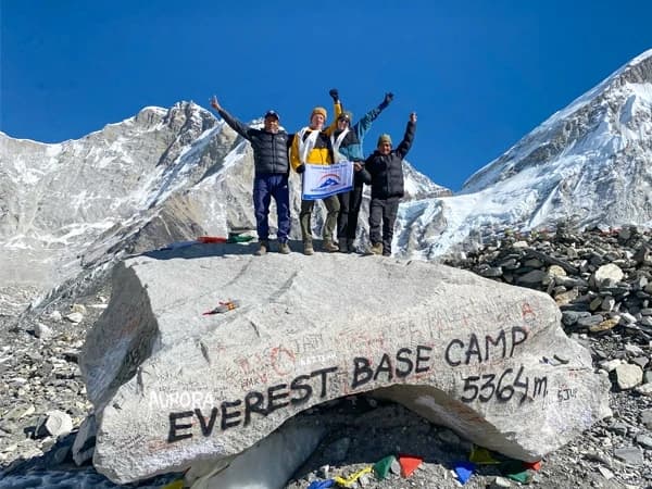 Trekkers standing at Everest Base Camp after completing the challenging high-altitude trek in Nepal.