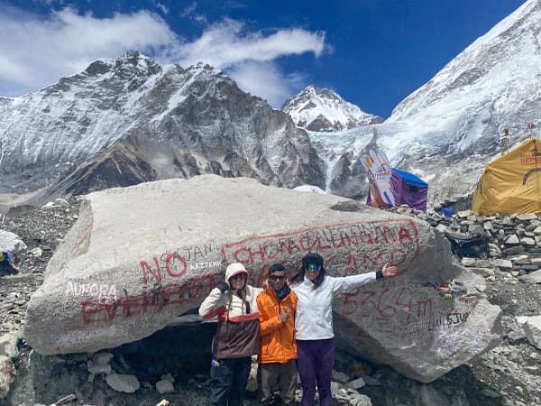 Female trekkers with backpack overlooking the Himalayas during the Everest Base Camp trek.