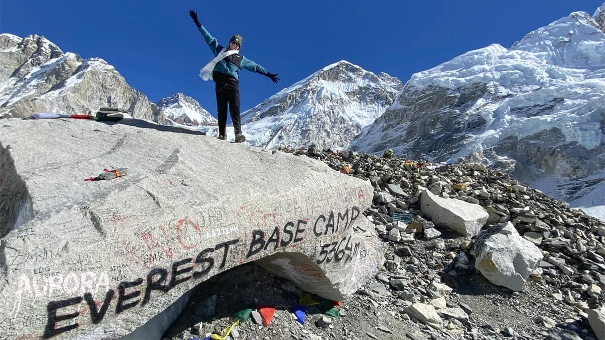 Trekker standing on a rock at Everest Base Camp, Khumbu region, Nepal - 5,364m